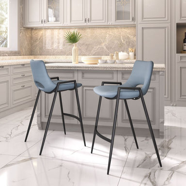 Two blue bar stools with black legs in a kitchen setting.