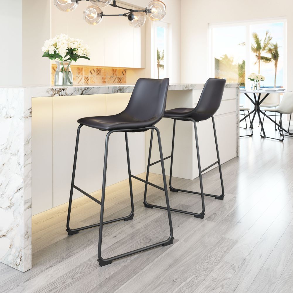 Two black bar stools in a modern kitchen setting with white cabinets and light wood flooring.