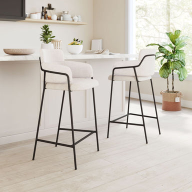 Two bar stools with black legs and white seats in a modern kitchen setting.