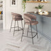 Two brown bar stools in a kitchen setting with a countertop and decor.