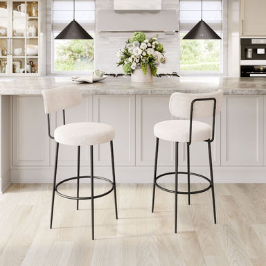 Two white bar stools with black legs in a modern kitchen setting.