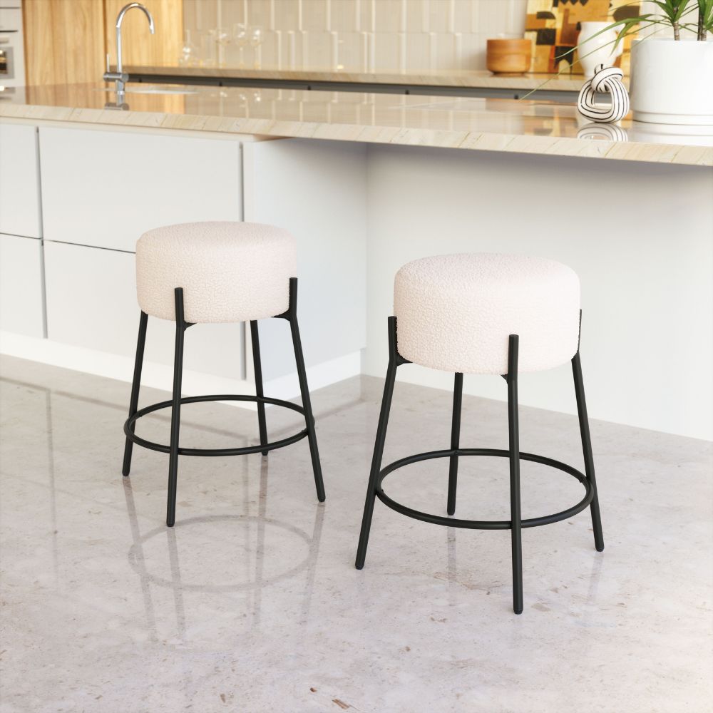 Two bar stools with white seats and black metal frames in a kitchen setting.