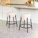 Two bar stools with white seats and black metal frames in a kitchen setting.