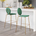 Two green bar stools with gold legs in a kitchen setting.