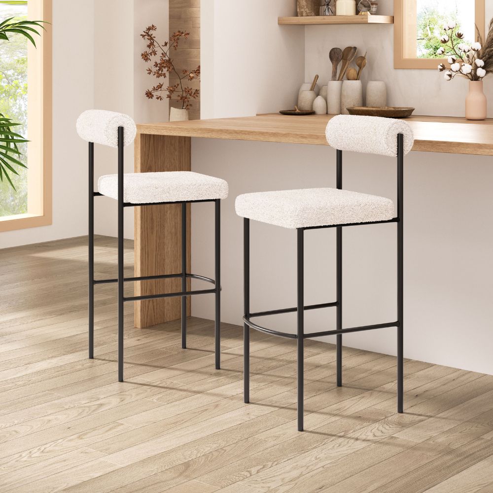 Two bar stools with white cushioned seats and black metal frames in a kitchen setting.