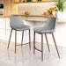 Two gray bar stools with wooden legs in a kitchen setting.