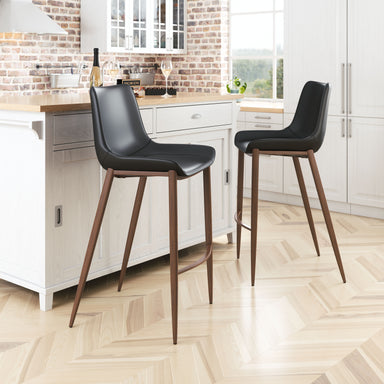 Two black bar stools with wooden legs in a kitchen setting.