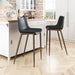 Two black bar stools with wooden legs in a kitchen setting.