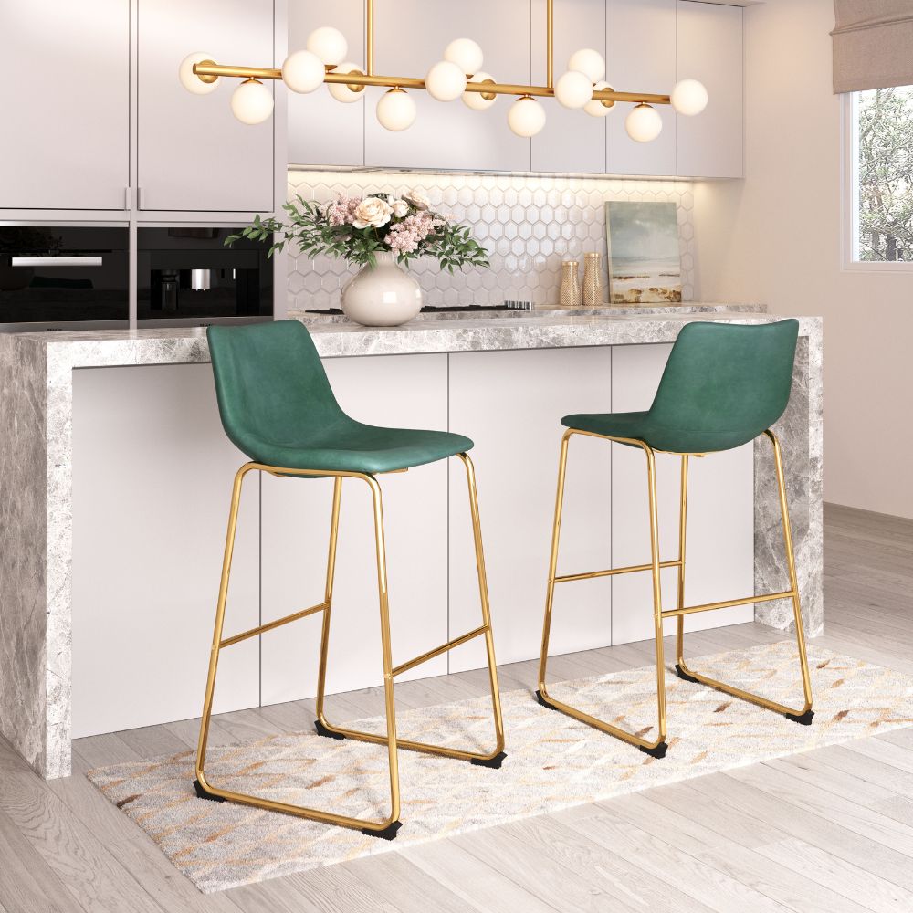 Two green bar stools with gold legs in a modern kitchen setting.