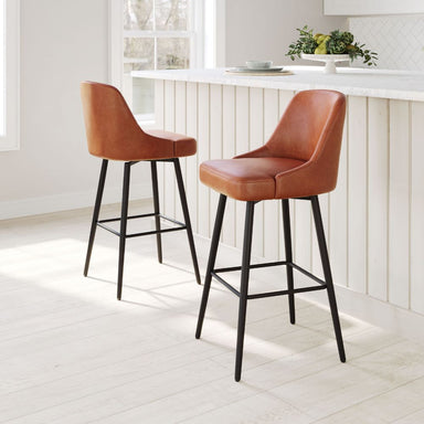 Two brown leather bar stools with black legs in a kitchen setting.