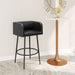 Black bar stool in a room with a round table and decorative mirror.