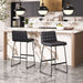 Modern kitchen with marble island, black bar stools, and pendant lights.