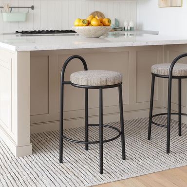 Two bar stools with cushioned seats in a kitchen setting.