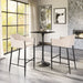 Modern bar height table with two stools in a stylish room with large windows and decorative wall art.
