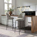 Modern kitchen with two gray bar stools and a wooden countertop.