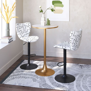 Two patterned bar stools with a gold table in a room setting.