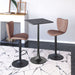 Two brown bar stools with black legs and a small square table on a marble floor.