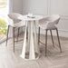 White round table with two chairs on a wooden floor in a room with large windows.