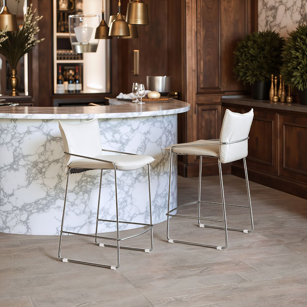 Two white bar stools in front of a marble island in a kitchen setting.