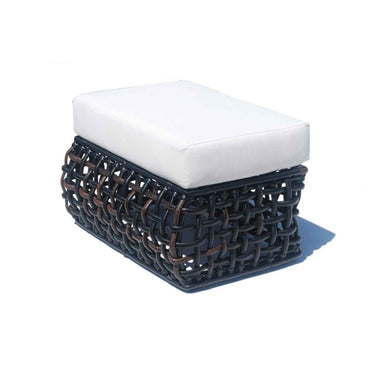 Woven ottoman with a white cushion on a white background