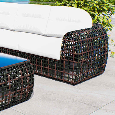 Wicker outdoor furniture set with white cushions on a patio