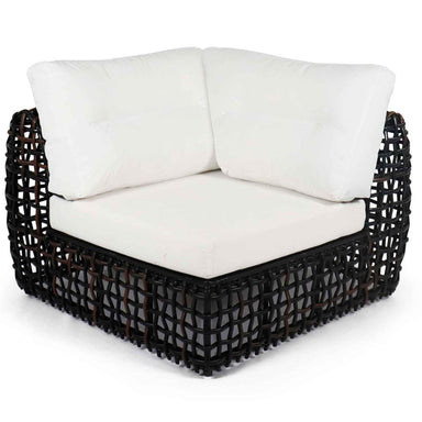 Black wicker corner chair with white cushions on a white background
