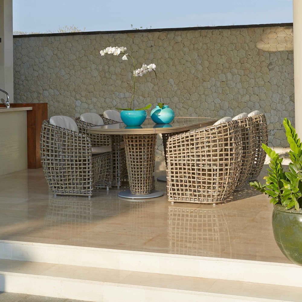 Outdoor patio set with wicker chairs and table on a tiled floor.