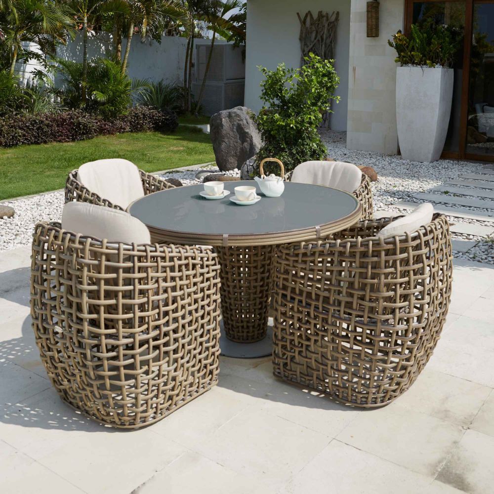 Outdoor patio set with wicker chairs and table in a garden setting