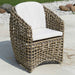 Woven outdoor chair with white cushion on a patio