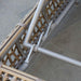 Close-up of a woven chair with metal frame on a concrete floor