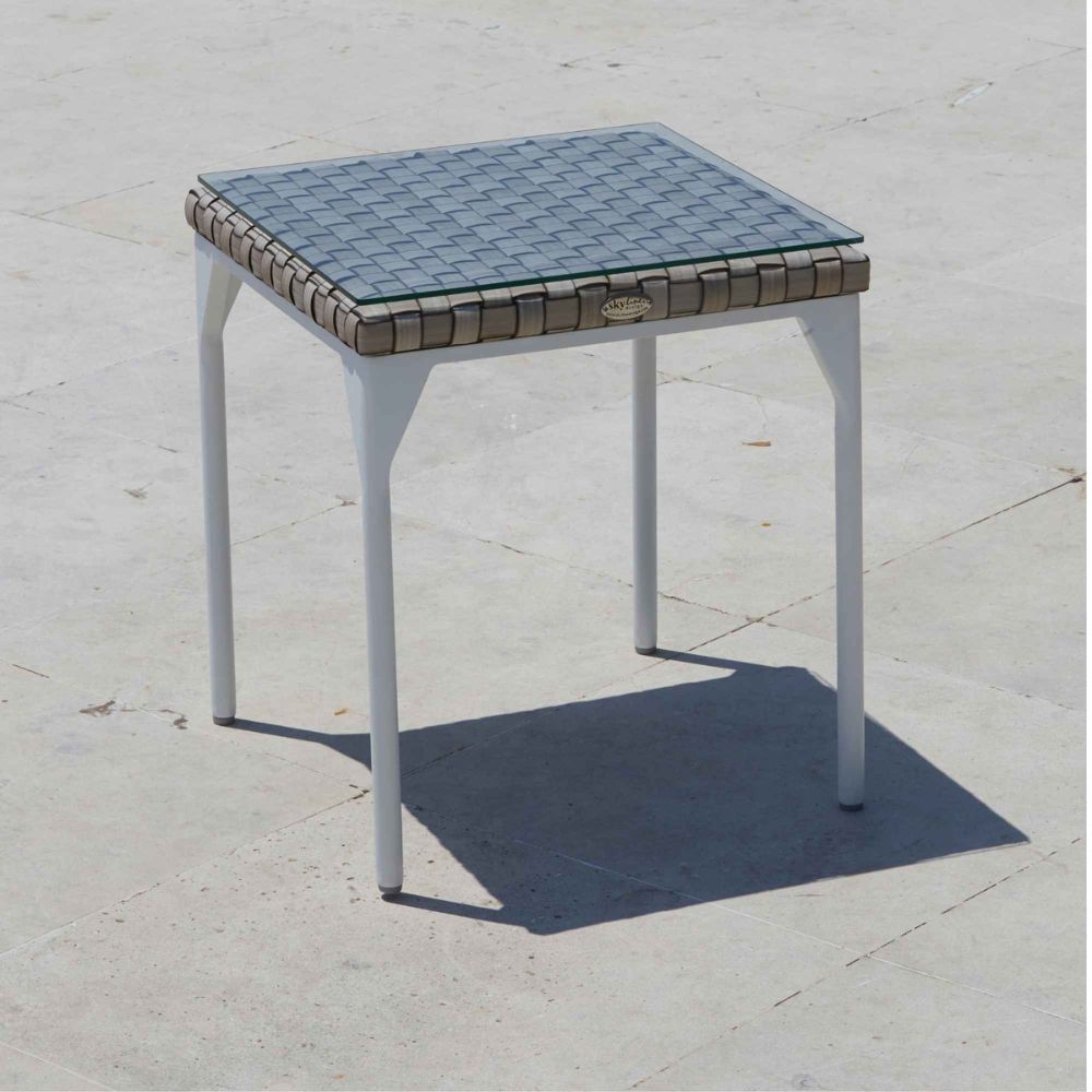 Small square table with a tiled top on a concrete surface