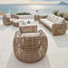 Outdoor patio furniture set with wicker chairs and table on a terrace with ocean view