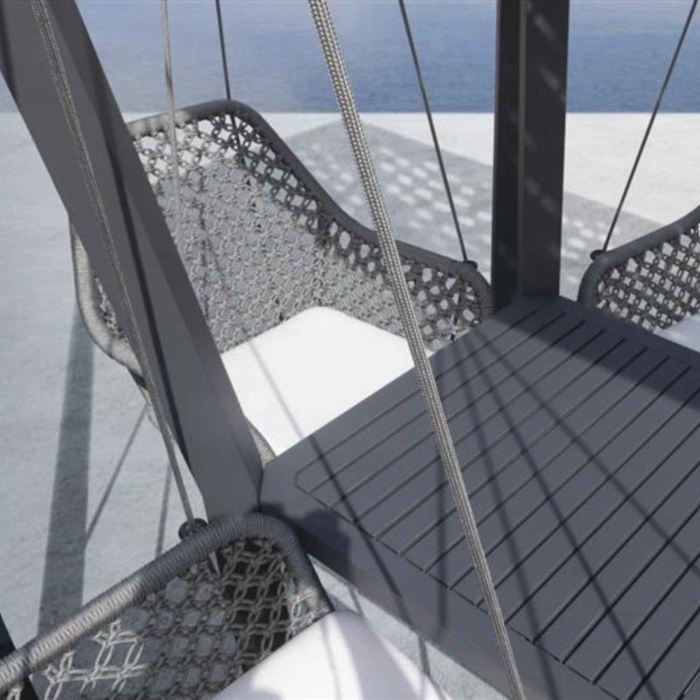 Close-up of a swing with woven seat and metal frame on a sunny day.