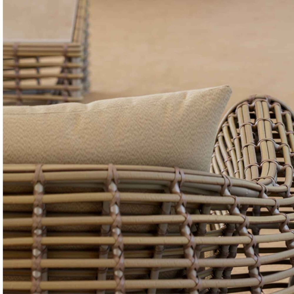 Close-up of a woven chair with a cushion on a beige background