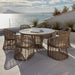 Outdoor dining set with round table and chairs on a patio overlooking water.