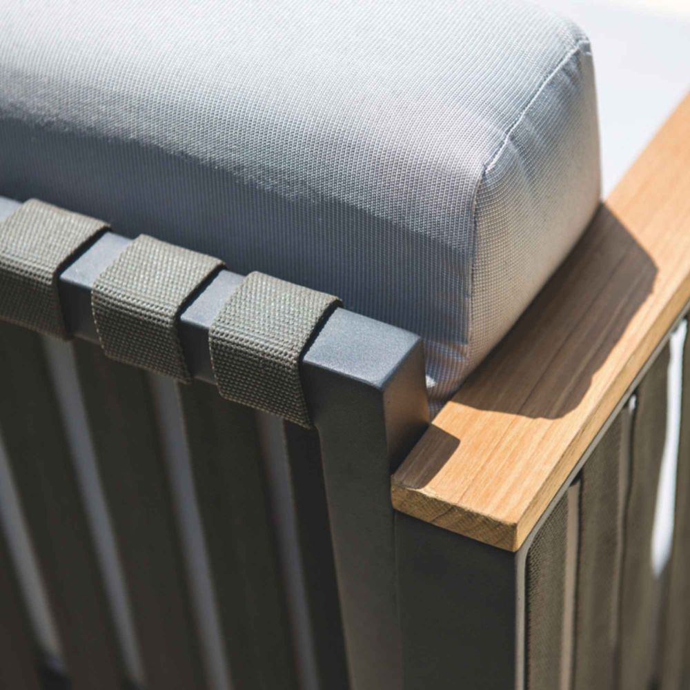 Close-up of a chair with gray cushion, black metal frame, and wooden armrest.