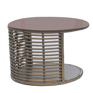 Round glass table with wicker-like base on a white background