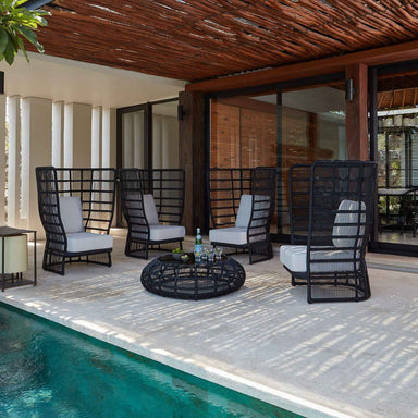 Outdoor patio area with black chairs, a table, and a pool.