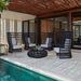 Outdoor patio area with black chairs, a table, and a pool.