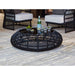 Round black wicker coffee table with drinks and snacks on a patio