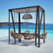 Outdoor seating area with wicker chairs and a hanging lamp, set against a scenic ocean view.