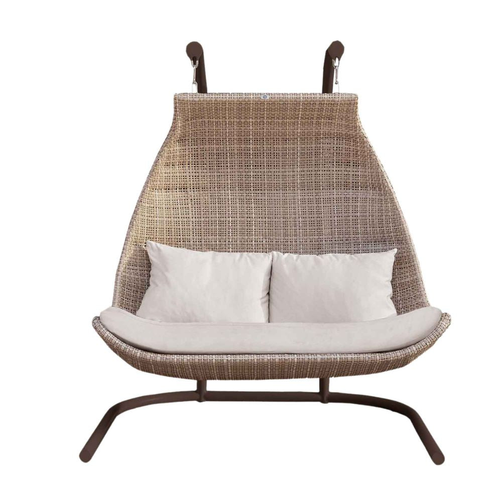 Hanging chair with wicker design and white cushions on a white background