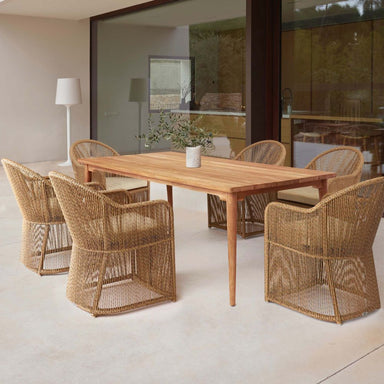 Dining area with wooden table and wicker chairs in a modern interior setting.