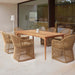Dining area with wooden table and wicker chairs in a modern interior setting.