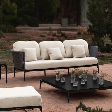 Outdoor furniture set with a sofa and coffee table in a garden setting