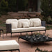 Outdoor furniture set with a sofa and coffee table in a garden setting