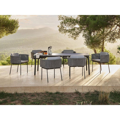 Outdoor dining set with table and chairs on a patio with a scenic background