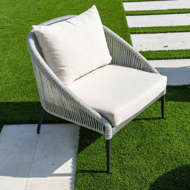 Outdoor chair with white cushions on a grassy area
