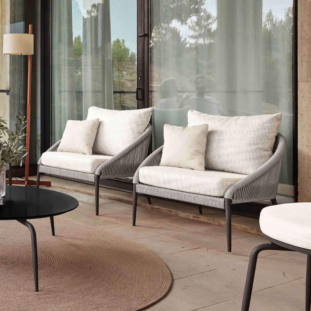 Modern outdoor furniture set with two sofas and a coffee table on a wooden deck.