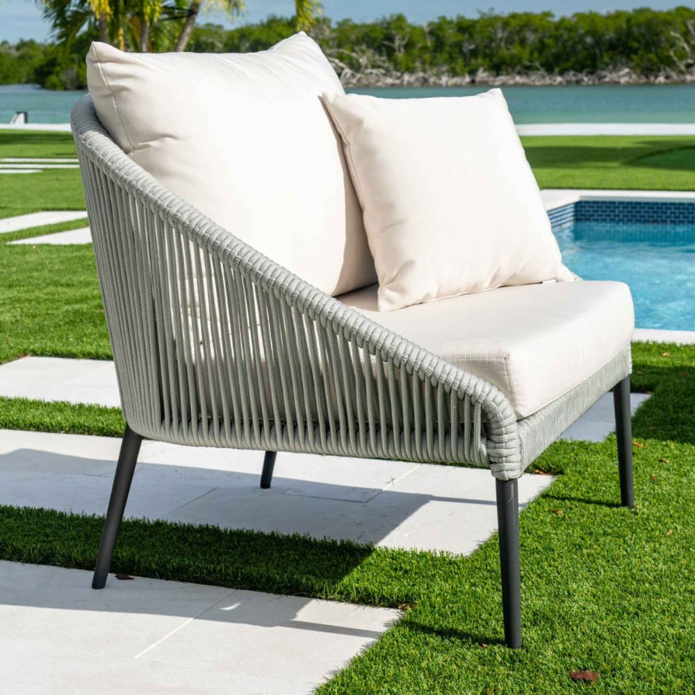 Outdoor patio chair with white cushions by a poolside